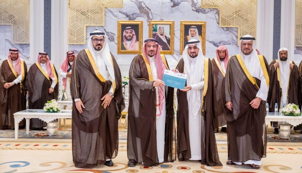 Academic honoring at Qassim University in the presence of leadership, highlighting the official nature and national pride.