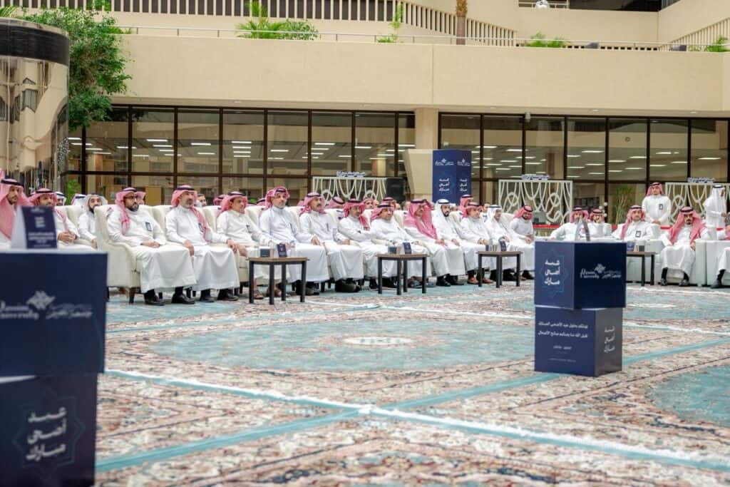 حضور منسوبي جامعة القصيم لفعالية عيد الأضحى في قاعة داخلية بأجواء اجتماعية رسمية.